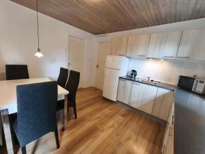 a kitchen and dining room with a table and chairs at Riverview Cottage in Randbøl