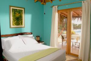 Un dormitorio con una cama y una puerta corrediza de vidrio. en Guille Bungalows, en Canoas de Punta Sal