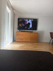 a living room with a flat screen tv on a dresser at Am Hohentwielblick in Singen