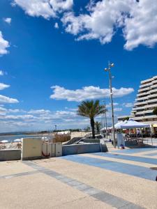 a skate park next to a beach with a palm tree at Appartement au coeur de la Grande Motte, vue mer in La Grande-Motte