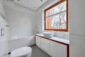 un bagno con un water, un lavandino e una finestra di Sopot Kamienny Potok by NorthSide Apartments a Sopot Altre 20 foto