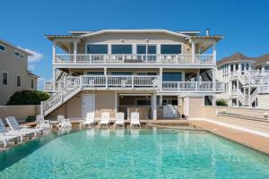 een huis met een zwembad en stoelen ervoor bij SNH345 Take It to the Limit in Nags Head