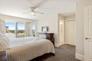 een slaapkamer met een bed, een plafondventilator en een raam bij SNH345 Take It to the Limit in Nags Head +106 foto's