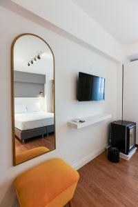a bedroom with a mirror and a bed and a tv at QonuQ Bozcaada in Bozcaada