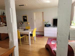 a living room with a table and yellow chairs at Wohnung Waltraud in Plattenburg
