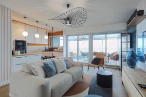 a living room with a couch and a kitchen at Superbe appartement haut de gamme 4 personnes en Front de mer in Plérin