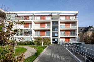 an apartment building with a walkway in front of it at Superbe appartement haut de gamme 4 personnes en Front de mer in Plérin