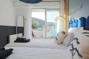 a bedroom with a bed with white sheets and blue surfboards at Superbe appartement haut de gamme 4 personnes en Front de mer in Plérin