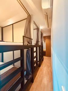 バンコクにあるThe LODGE BKK Hostelの二段ベッド3組と廊下が備わる客室です。