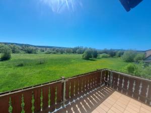 a balcony with a view of a large green field at Ferienhaus bayerische Rhön in Ostheim