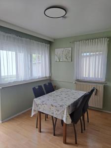 a dining room with a table and chairs and windows at Ferienhaus bayerische Rhön in Ostheim