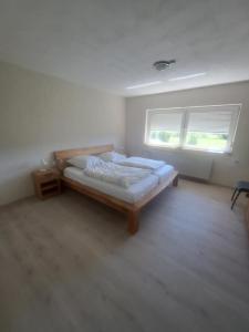 a bedroom with a bed and two windows at Ferienhaus bayerische Rhön in Ostheim