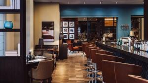 a bar in a restaurant with brown chairs at AMERON Köln Hotel Regent in Cologne