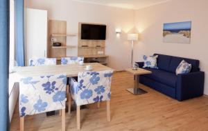 a living room with a table and a blue couch at FeWo Brak in Norddeich