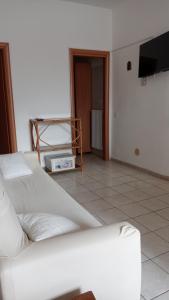 a living room with a white couch and a tv at Casa David in Cava deʼ Tirreni