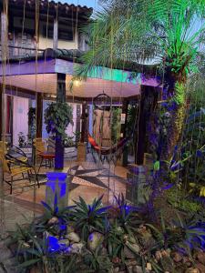 a house with a hammock in the middle of a garden at Vila Pequeá Ilhabela in Ilhabela