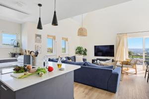 a kitchen and living room with a blue couch at No 3 The Vista, Willingcott, Woolacombe in Woolacombe