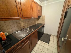 a small kitchen with a sink and wooden cabinets at Mandarin B10 in Crans-Montana +6 photos