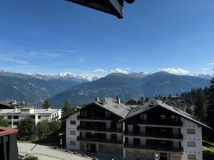 a view of a building with mountains in the background at Mandarin B10 in Crans-Montana