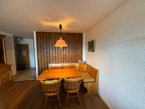 a wooden dining room table with chairs and a lamp at Mandarin B10 in Crans-Montana
