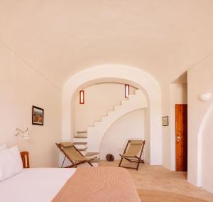 a bedroom with two chairs and a staircase at Quinta do Pinheiro in Pinheiro
