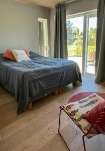 a bedroom with a bed and a large window at Lake Cottage With Sunsets Over Försjön in Eksjö