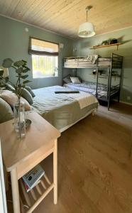 a bedroom with two bunk beds and a table at Lake Cottage With Sunsets Over Försjön in Eksjö