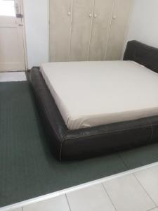 a bed with a black leather bed frame in a room at Halibut Suite in Strand