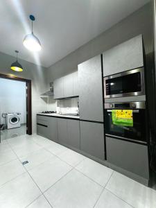 a kitchen with a stove and a microwave at Luxury House in Brazzaville