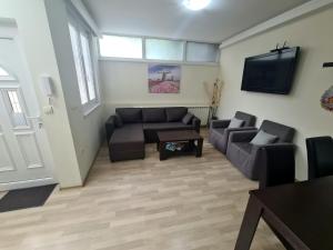 Una sala de estar con un sofá y un televisor. en Fantastic Belgrade Nights, en Belgrado