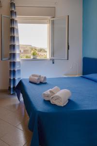a blue bedroom with two beds with towels on them at Residence Le 4 Stagioni in Menfi +239 photos