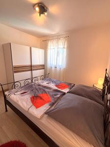 a bedroom with a bed with red pillows on it at Apartments Quarnero Rabac in Rabac