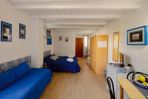a living room with a blue couch and a bed at Residence Le 4 Stagioni in Menfi