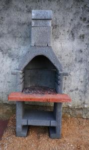 a stone oven sitting next to a wall at Panorama Apartments in Povljana