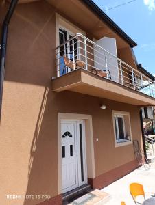 una casa con dos perros sentados en un balcón en Garfield Family Apartman 2, en Soko Banja 30 fotos más