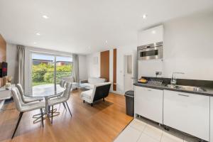 a kitchen and living room with a table and chairs at Spacious 2BR 2BA Ground Floor Apartment in RG2 - Ideal for Contractors & Business Stays, FREE Parking & Sleeps Up To 7! in Reading