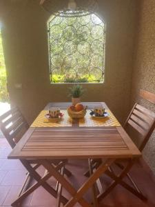 a wooden table with two chairs and a bowl of fruit on it at La Casina di Checco in Marciana Marina