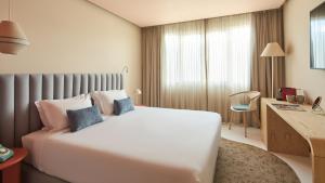 a hotel room with a bed and a desk at Hotel Indigo Albufeira by IHG in Albufeira