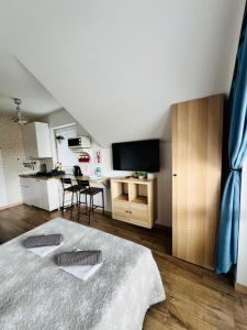 a bedroom with a large bed and a kitchen at Villa NOVA Dębki in Dębki