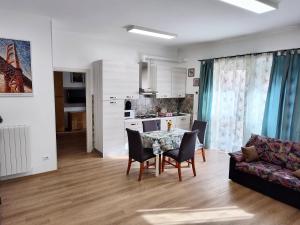 a kitchen and living room with a table and chairs at Appartamento RALUCA in Acilia