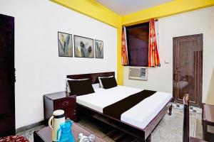 un dormitorio con una cama y una ventana en Hotel O Raj Mahal, en Kānpur