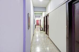Un pasillo con paredes blancas y suelo de baldosas. en Hotel O Raj Mahal, en Kānpur