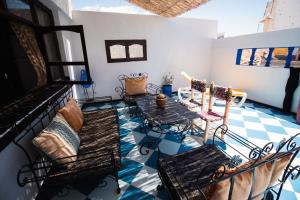 a room with a table and chairs on a tile floor at Bird Guesthouse in Taghazout