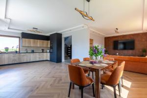 a dining room and kitchen with a table and chairs at Ogrodowy Zakątek in Łebcz