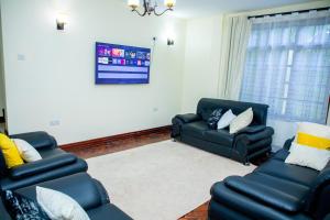 a living room with two chairs and a couch at Oasis Homestay in Arusha