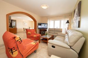 un salon avec un canapé blanc et des chaises dans l'établissement Beachfront Apartments Tolo with Pool, à Novalja