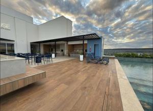 a building with a deck with tables and chairs at Estúdio novo com mobília completa in Barreiras