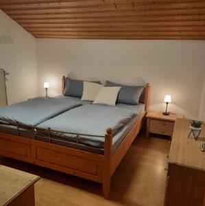 ハウツェンベルクにあるFerienwohnung PanoramaBlickの大型ベッド1台、テーブル2台、ランプ2つが備わる客室です。