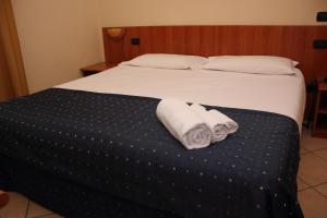 a bed with two towels sitting on top of it at Albergo Hotel Giardino in Desio