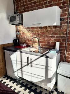 a kitchen with a sink and a brick wall at Victorian Loft Living Hotel 22 in London +92 photos